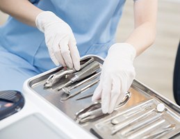 기구 트레이를 정리하는 장갑 낀 손