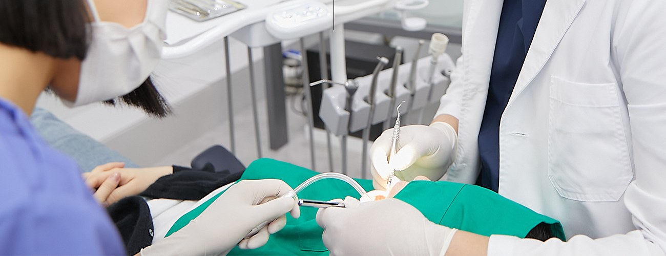 진료 의자에 누운 환자의 치아를 치료하는 의료진