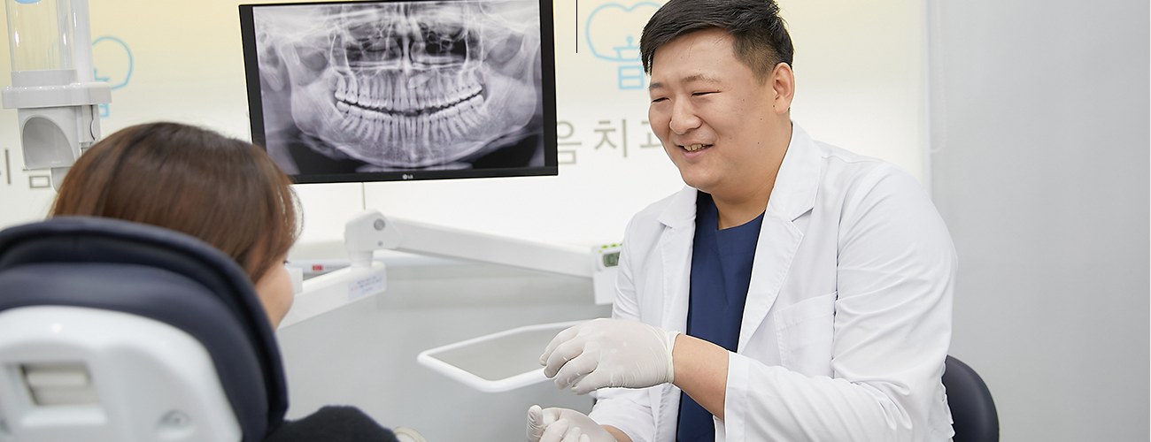 진료실 모니터에 파노라마 X-ray를 띄워 두고 환자와 상담하는 의사